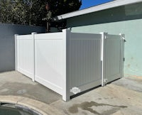 a white vinyl fence next to a swimming pool