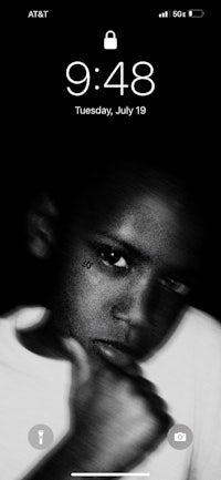 a black and white image of a young boy on an iphone