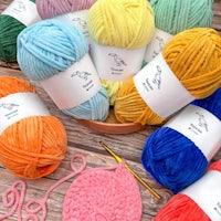 a bowl full of colorful yarn and knitting needles