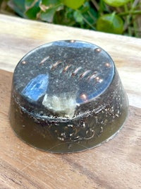 a small soap dish with a blue stone on top of it
