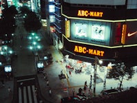 a city street at night with a nike store