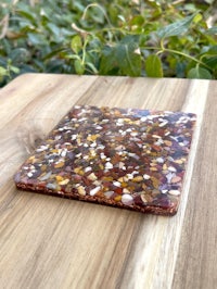 a wooden coaster with a brown and white speckled pattern