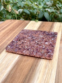 a purple stone coaster on top of a wooden table