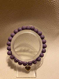 a purple bead bracelet on a white surface