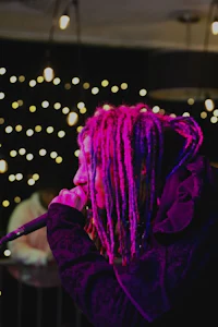 a man with dreadlocks singing into a microphone