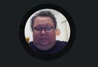 a man with glasses is taking a selfie on his phone