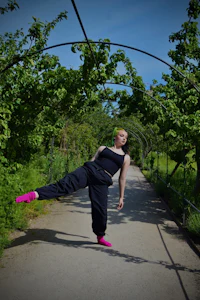 a woman is doing a yoga pose in a park