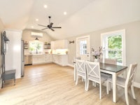 a kitchen with wood floors and a ceiling fan