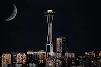 seattle skyline at night with the moon and space needle