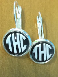 a pair of earrings with the word thc on them