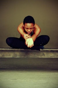 a woman sitting on a bench with her hands on her hips