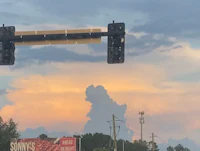 a street sign with a cloud in the background