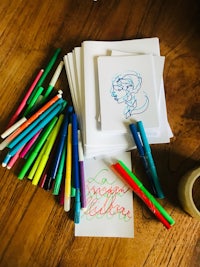 a set of colored markers and pens on a wooden table