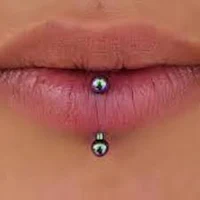 a woman's lip with a black pearl piercing