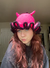 a girl wearing a pink crocheted hat