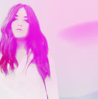 a woman with long hair standing in front of a pink and purple background