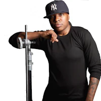 a black man with a yankees hat leaning against a pole