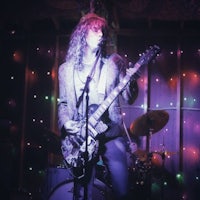 a man playing a guitar in front of colorful lights