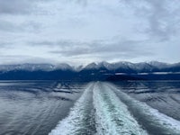 the back of a boat with mountains in the background
