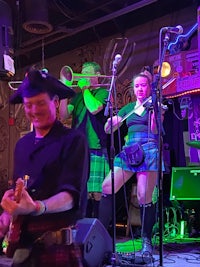 a group of people in kilts playing music at a bar