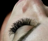 a close up of a woman's eye with long lashes