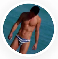 a man in a blue and white bikini standing in the water