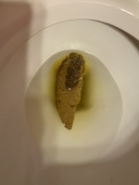 a toilet bowl with a piece of meat in it