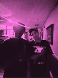 two men standing in front of a purple light