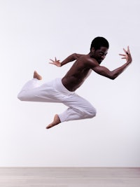 a black man in white pants is jumping in the air