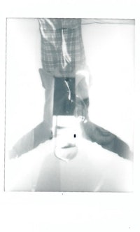 a black and white photo of a person standing in front of a mirror
