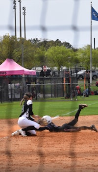 a softball player sliding into home plate