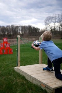 a young boy is playing with a toy on a wooden platform
