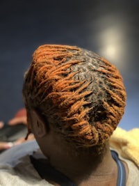 the back of a person with orange dreadlocks