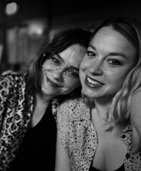 two women posing for a photo at a bar