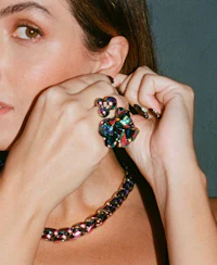 a woman is posing with a necklace and earrings
