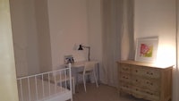 a small room with a bed and dresser