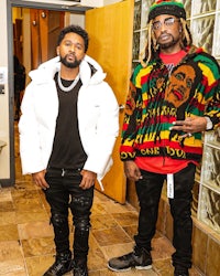 two men standing next to each other in a bathroom