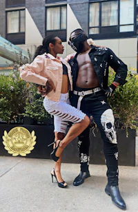 a man and woman posing for a photo in front of a building