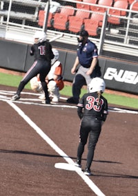 a group of girls playing softball on a field