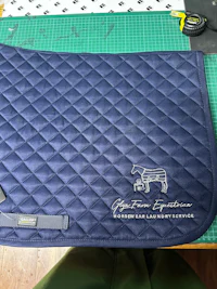 a blue saddle pad with a horse on it