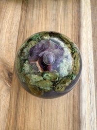 an amethyst sphere on top of a wooden table
