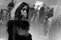 a black and white photo of a woman wearing a mask