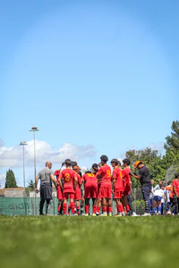 a group of soccer players huddle on a field