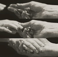 a black and white photo of two hands holding each other
