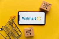 a smartphone with the walmart logo and shopping carts on a yellow background