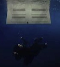 a man is scuba diving in the water with a white box