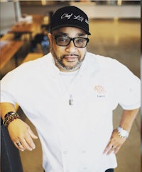 a man in a chef's uniform posing for a photo