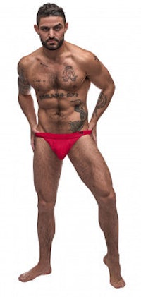 a man in a red bikini with tattoos posing