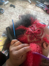 a woman with red hair is getting her hair cut