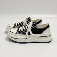 a pair of black and white sneakers on a white surface